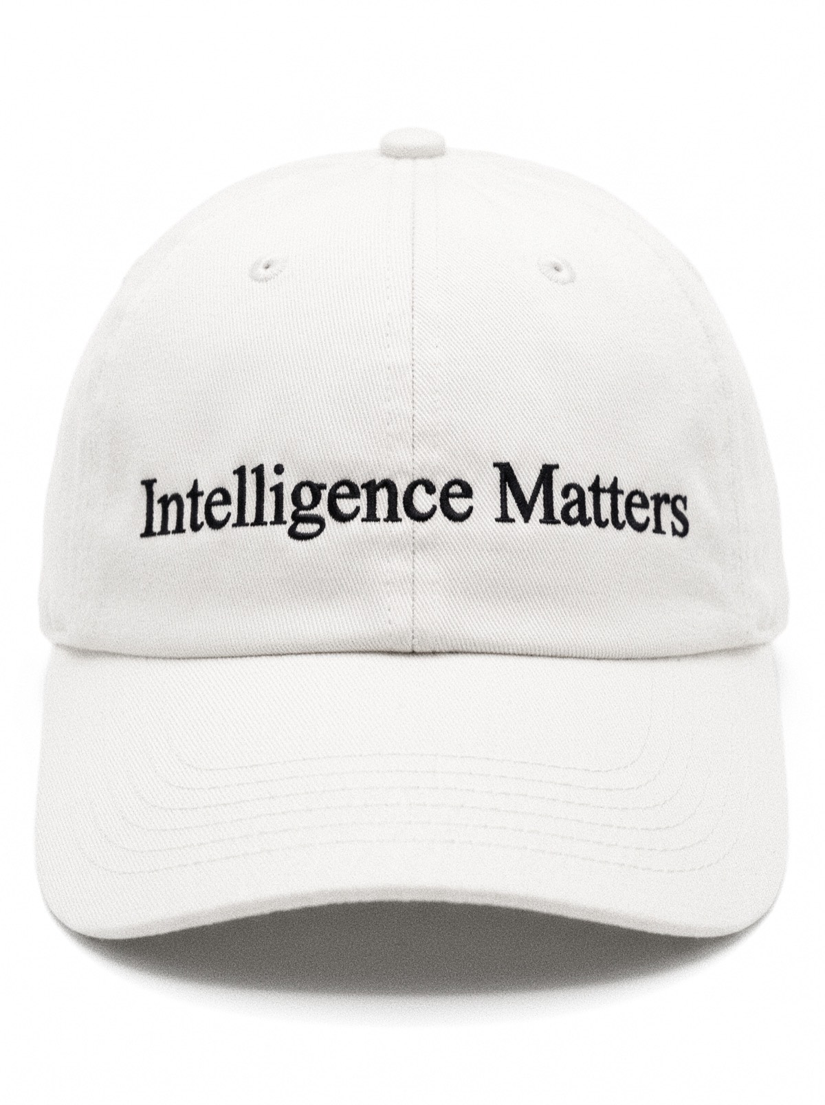 An off-white unstructured six-panel cap, front on, Intelligence Matters embroidered across the front in a black serif